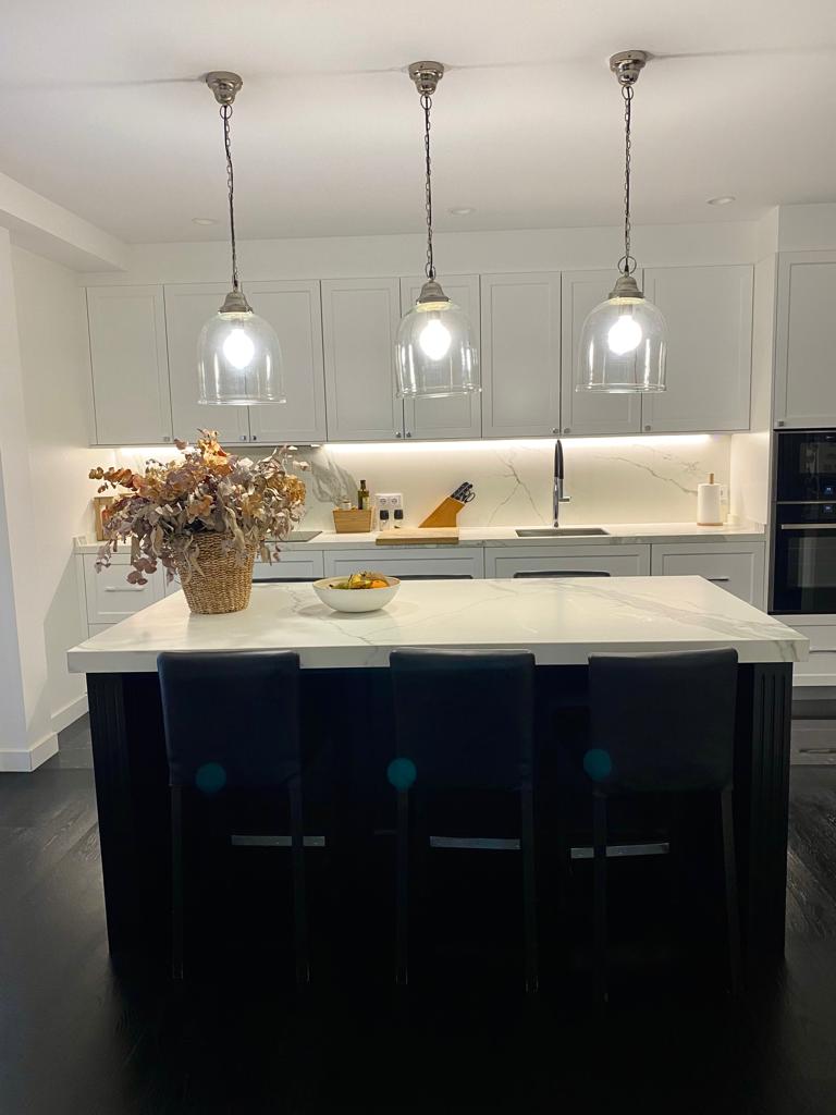 Cocina reformada con isla central y mobiliario integrado en vivienda de Barcelona