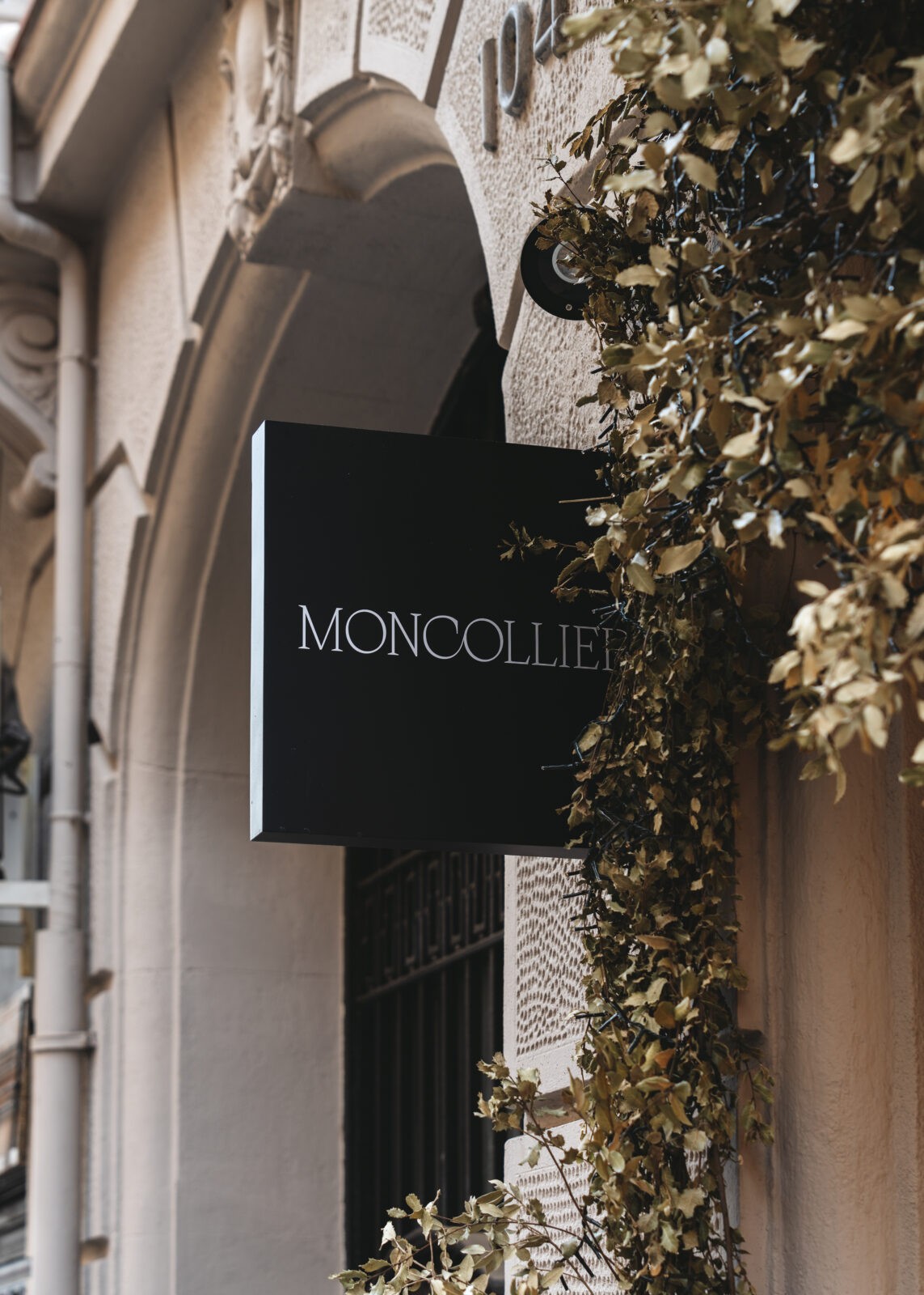 Rótulo tipo banderola en la fachada de la boutique de MONCOLLIER en Barcelona