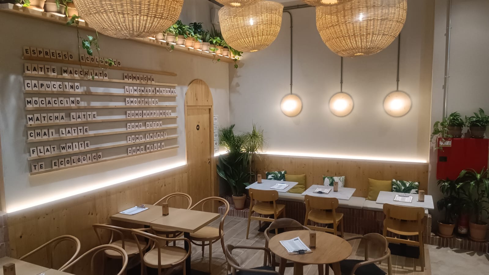 Zona de comensales de Green Vita Brunch con lámparas colgantes de mimbre