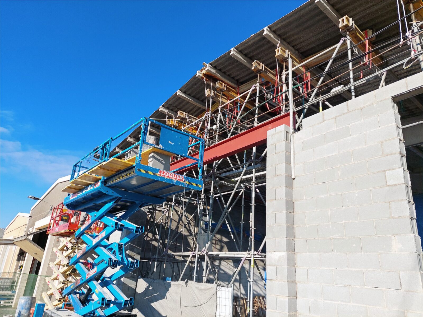 Colocación de viga estructural tipo dintel en la fachada de nave industrial