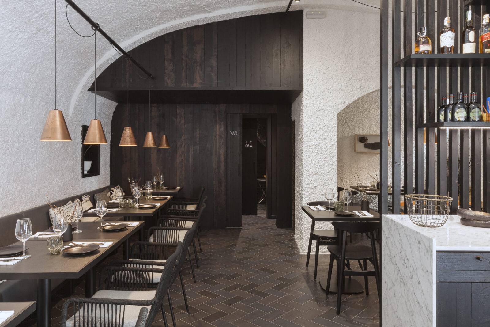 Vista del interior del restaurante Brasic en Figueres con arcos, estucado y revestimientos de madera
