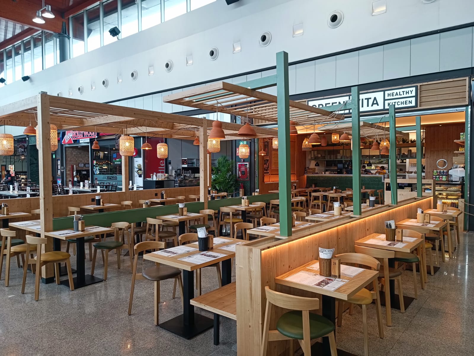 Terraza del restaurante Green Vita con pérgola de madera y mesas