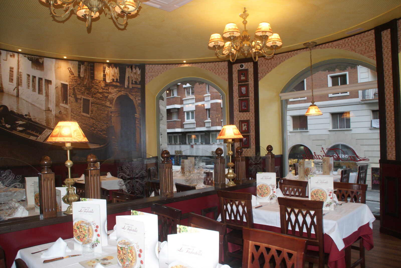 Interior del restaurante con grandes ventanales, mesas y sillas en La Rotonda